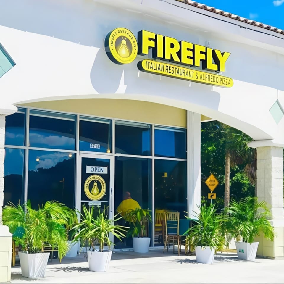 The exterior of Firefly Italian Restaurant & Alfredo Pizza, with large windows and potted plants.