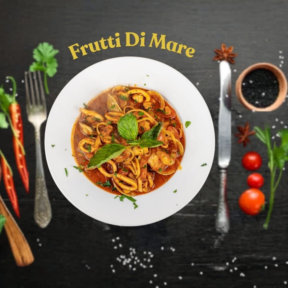 Frutti Di Mare pasta with seafood, basil, and red sauce, garnished with spices and vegetables.